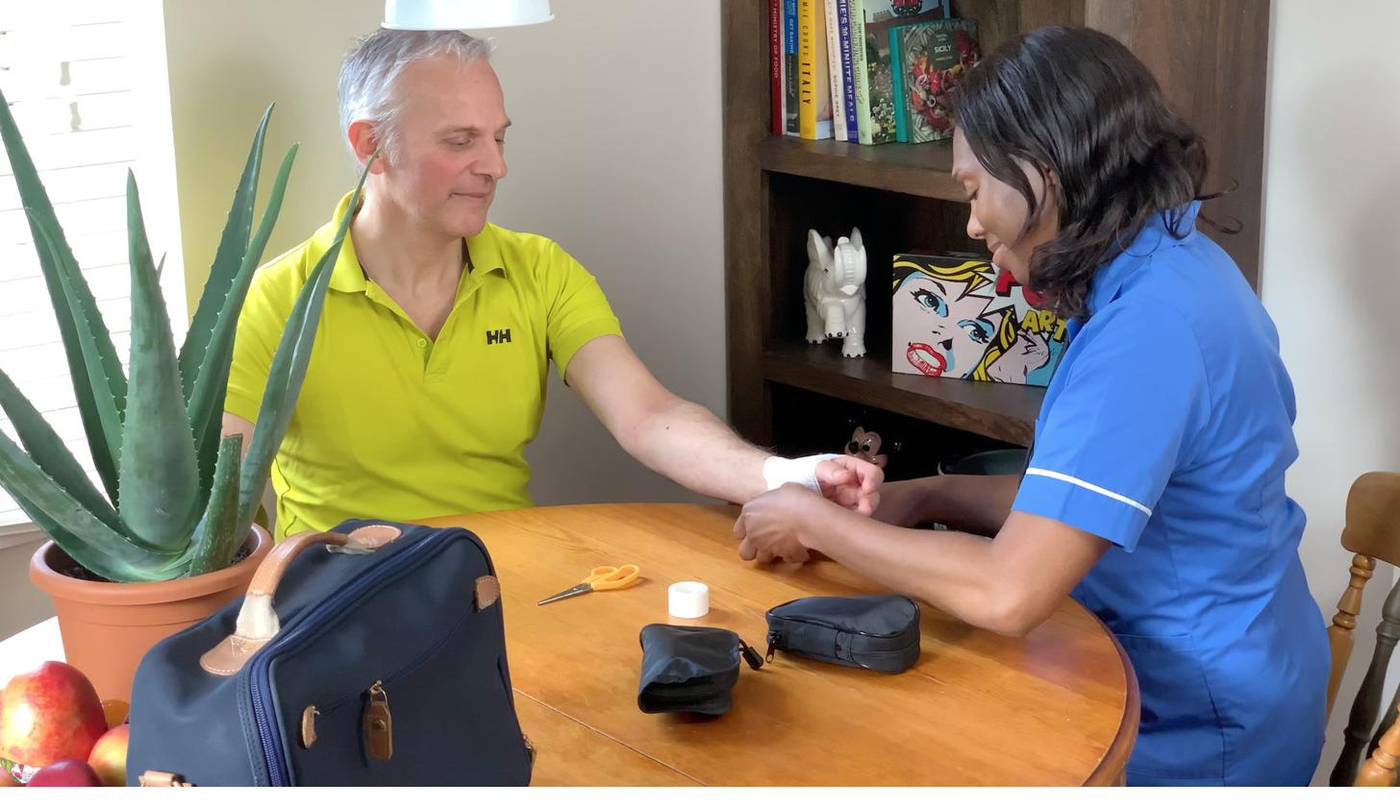 A nurse attending to a client at home